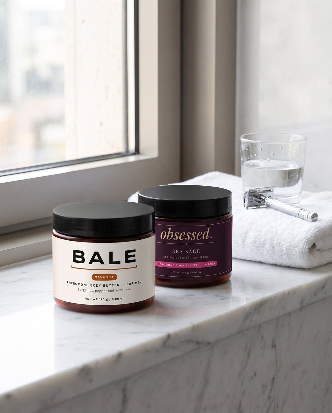 Bale Savanna jar beside its obsessed partner Sea Sage on a marble bathroom shelf by a window