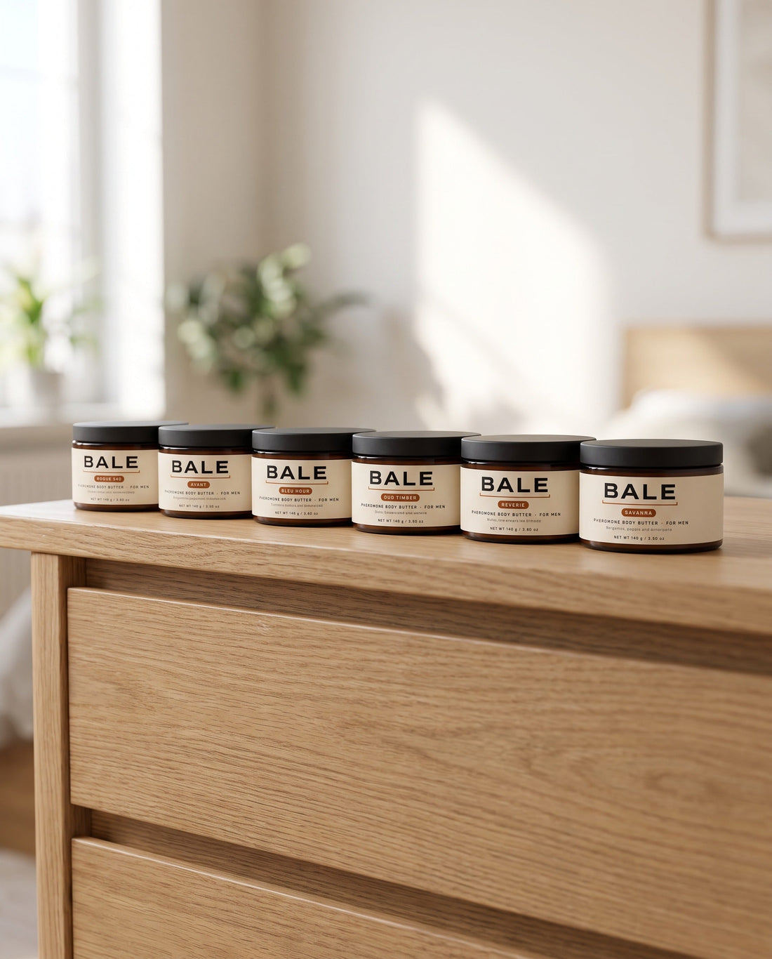 All six Bale body butter scents in a row on an oak dresser