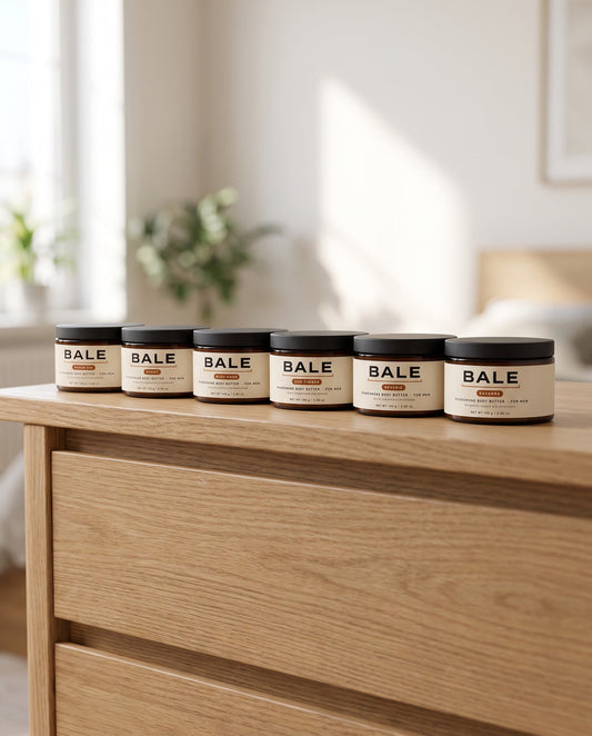 All six Bale body butter scents in a row on an oak dresser