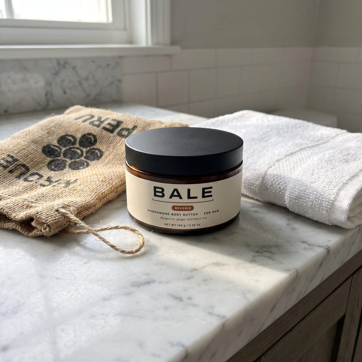Reverie jar on a marble vanity beside a coffee sack and a towel
