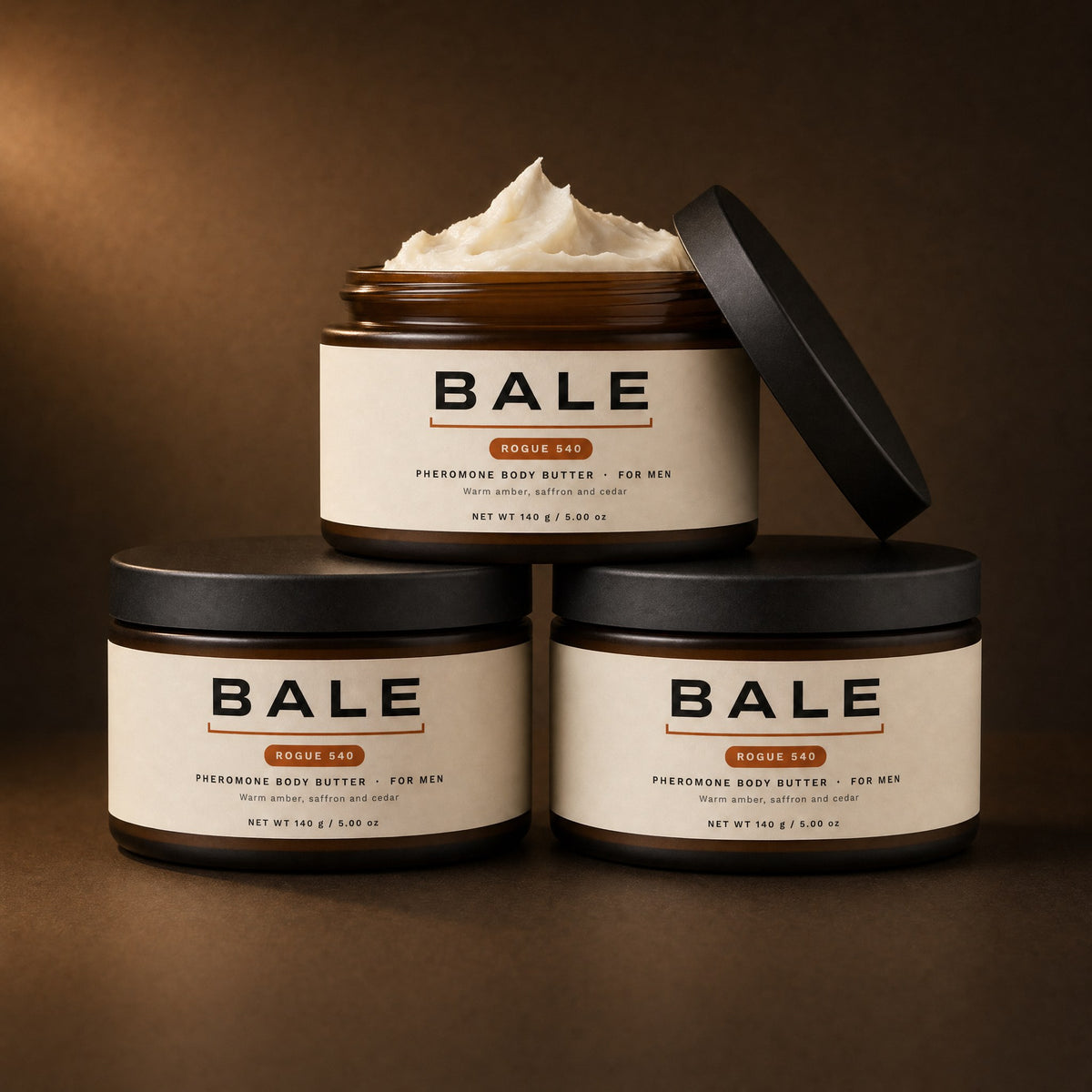 Three jars of Bale pheromone body butter, one open showing the whipped butter