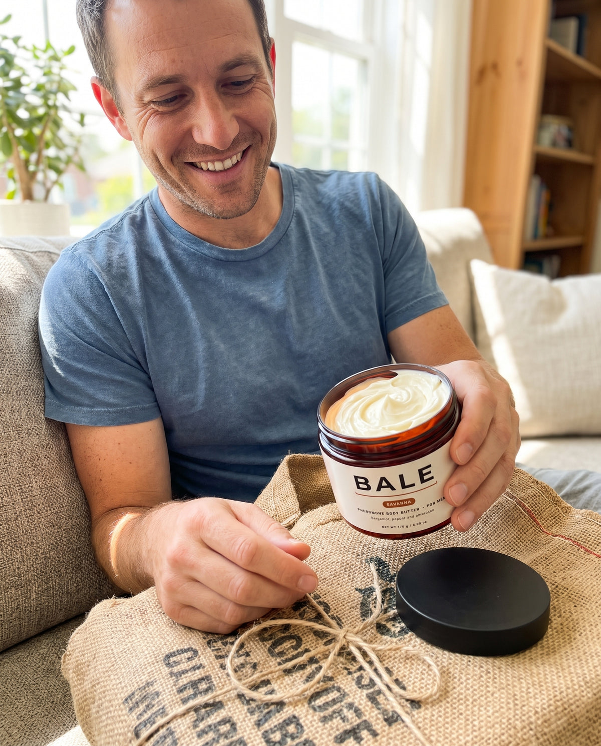 Man opening a coffee sack wrapped order, holding a jar of Savanna